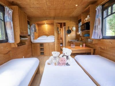 Hébergement insolite en Auvergne : cabane en bois avec lits jumeaux et peluches.