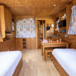 Hébergement insolite en Auvergne : chalet en bois lumineux avec deux lits simples.