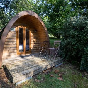 Cabane en bois à Limousin, avec terrasse et mobilier de jardin accueillant.