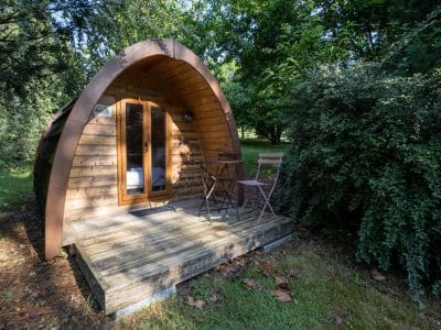 Cabane en bois à Limousin, avec terrasse et mobilier de jardin accueillant.
