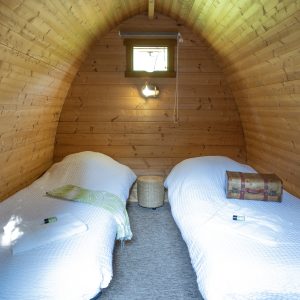 Hébergement insolite en bois à Champagne-Ardenne, avec deux lits confortables.
