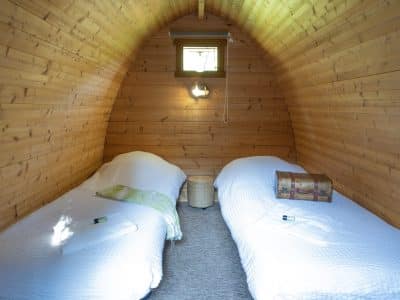 Hébergement insolite en bois à Champagne-Ardenne, avec deux lits confortables.