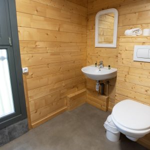 Toilette en bois dans un hébergement insolite à Limousin, ambiance chaleureuse et naturelle.