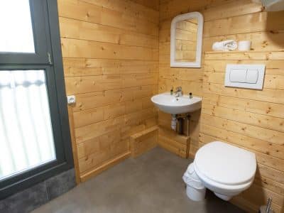 Toilette en bois dans un hébergement insolite à Limousin, ambiance chaleureuse et naturelle.