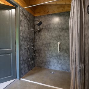 Salle de bain moderne dun hébergement insolite en Limousin, avec douche spacieuse.