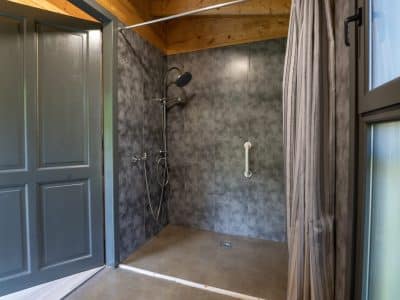 Salle de bain moderne dun hébergement insolite en Limousin, avec douche spacieuse.