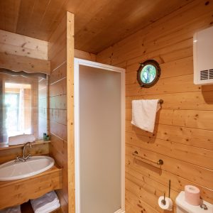 Salle de bain en bois dans un hébergement insolite à Limousin, lumineuse et accueillante.