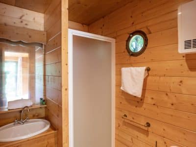Salle de bain en bois dans un hébergement insolite à Limousin, lumineuse et accueillante.