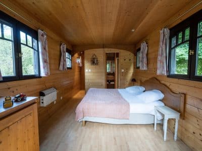 Chalet en bois chaleureux avec lit douillet et fenêtres lumineuses dans le Limousin.