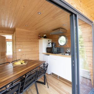 Hébergement insolite en Auvergne : chalet en bois avec vue sur la nature et cuisine équipée.