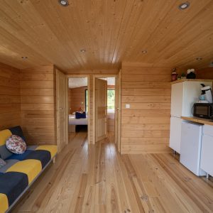 Hébergement insolite en Auvergne : intérieur en bois chaleureux avec canapé coloré.