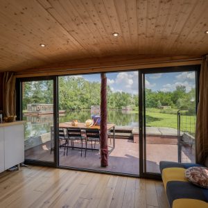 Hébergement insolite en Auvergne : un chalet en bois avec vue sur leau et la nature.