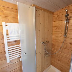 Douche moderne en bois dans un hébergement insolite au Limousin. Ambiance chaleureuse.