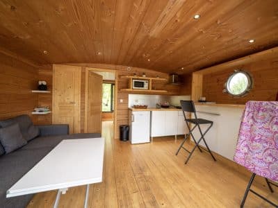 Hébergement insolite à Limousin : intérieur en bois chaleureux avec coin cuisine moderne.