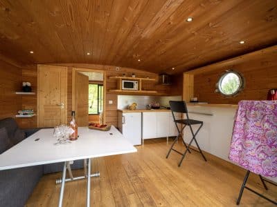 Hébergement insolite en Auvergne : intérieur en bois chaleureux avec cuisine équipée.