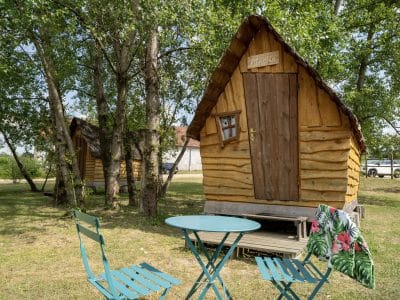 Cabane en bois typique en Auvergne, avec chaises et table en extérieur.
