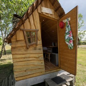 Cabane en bois à Auvergne, avec un toit en ardoise et une entrée accueillante.