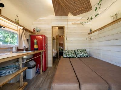 Hébergement insolite en Auvergne : un intérieur en bois avec un canapé confortable et réfrigérateur