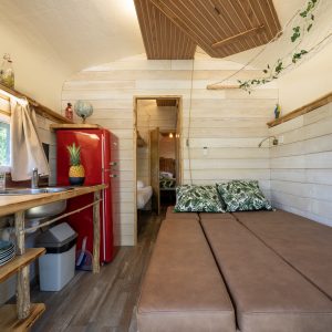 Hébergement insolite en Champagne-Ardenne : intérieur cosy avec un canapé et un frigo rouge.