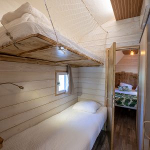 Hébergement insolite en Auvergne : cabane avec lits superposés et décor en bois.