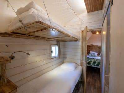 Hébergement insolite en Auvergne : cabane avec lits superposés et décor en bois.