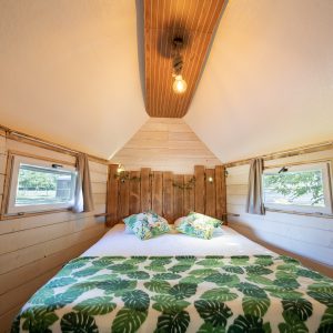 Cabane insolite en Auvergne avec lit douillet et décoration végétale.