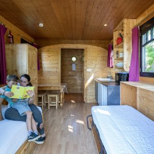 Hébergement insolite en Auvergne : intérieur en bois chaleureux avec lits simples.