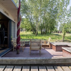 Hébergement insolite en Limousin : cabane sur pilotis avec terrasse en bois et vue verdoyante.