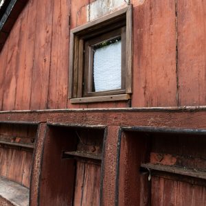 Hébergement insolite en Auvergne : cabane en bois avec fenêtre rustique et numérotée.
