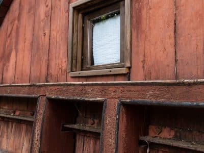 Hébergement insolite en Auvergne : cabane en bois avec fenêtre rustique et numérotée.