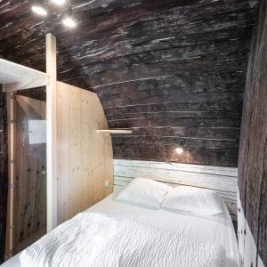 Chambre cocon en bois dans un hébergement insolite en Auvergne, ambiance chaleureuse.