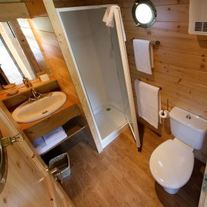 Cabane en bois en Auvergne avec salle de bain moderne et décor chaleureux.