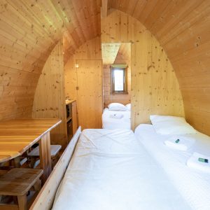 Hébergement insolite en Limousin : intérieur en bois chaleureux avec lit et table en bois.