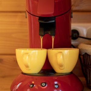 Café dans un hébergement insolite en Limousin, avec machine rouge et tasses jaunes.