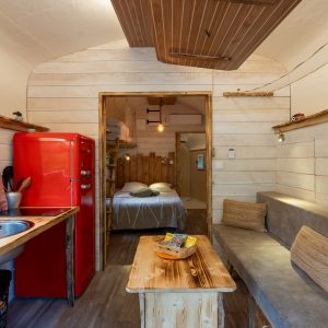 Cabane en bois à Champagne-Ardenne, avec un intérieur chaleureux et un frigo rouge vintage.