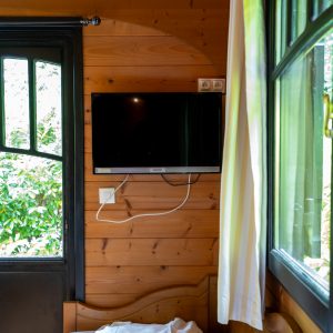 Chalet en bois à Champagne-Ardennes, intérieur chaleureux avec télévision et lumière naturelle.