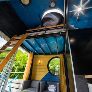 Cabane perchée à Champagne-Ardenne, avec un plafond étoilé et un coin salon cosy.