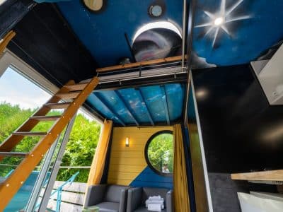 Cabane perchée à Champagne-Ardenne, avec un plafond étoilé et un coin salon cosy.