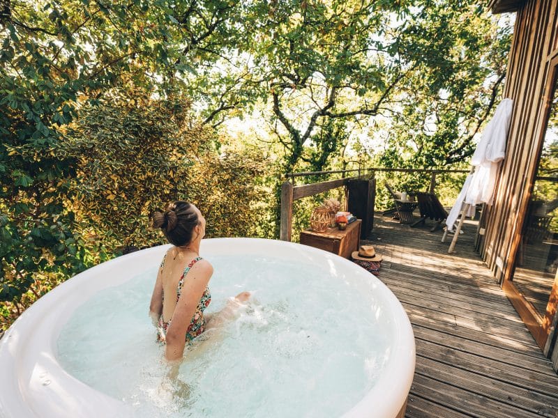 Cabane perchée en Midi-Pyrénées avec jacuzzi, entourée de verdure et de calme.