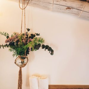 Hébergement insolite en Midi-Pyrénées avec décoration florale suspendue et serviettes blanches.