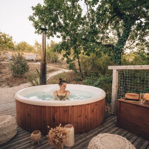 Hébergement insolite en Midi-Pyrénées avec jacuzzi en bois et décor naturel apaisant.