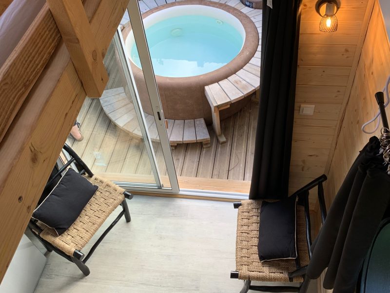 Hébergement insolite à Limousin : cabane avec jacuzzi extérieur et coin salon cosy.