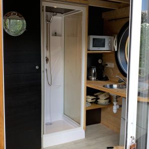 Hébergement insolite à Limousin : tiny house avec douche et cuisine intégrée.