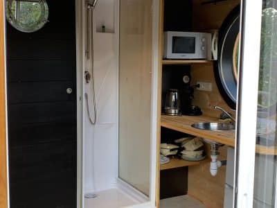 Hébergement insolite à Limousin : tiny house avec douche et cuisine intégrée.