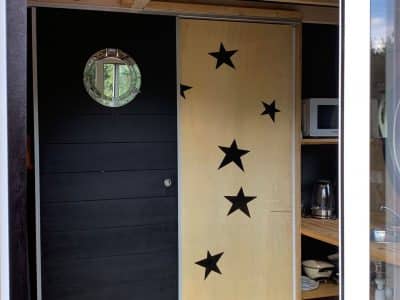 Hébergement insolite à Limousin : cabane moderne avec porte en bois décorée détoiles.