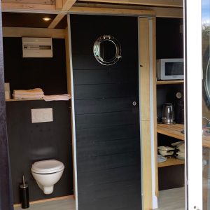 Hébergement insolite à Limousin : un chalet moderne avec kitchenette et salle de bain.