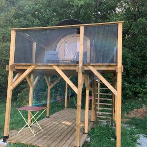 Hébergement insolite en cabane sur pilotis, avec terrasse en bois et vue sur la nature.