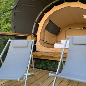 Hébergement insolite en bulle à Limousin, avec chaises longues sur une terrasse en bois.