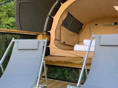 Hébergement insolite en bulle à Limousin, avec chaises longues sur une terrasse en bois.