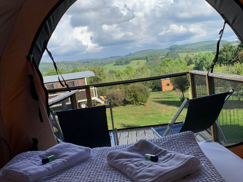 Tente de glamping avec vue panoramique sur la nature verdoyante du Limousin.